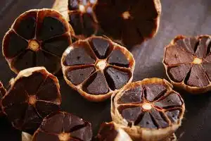 Halved cacao pods opened to reveal dark chocolate segments on a wooden surface.