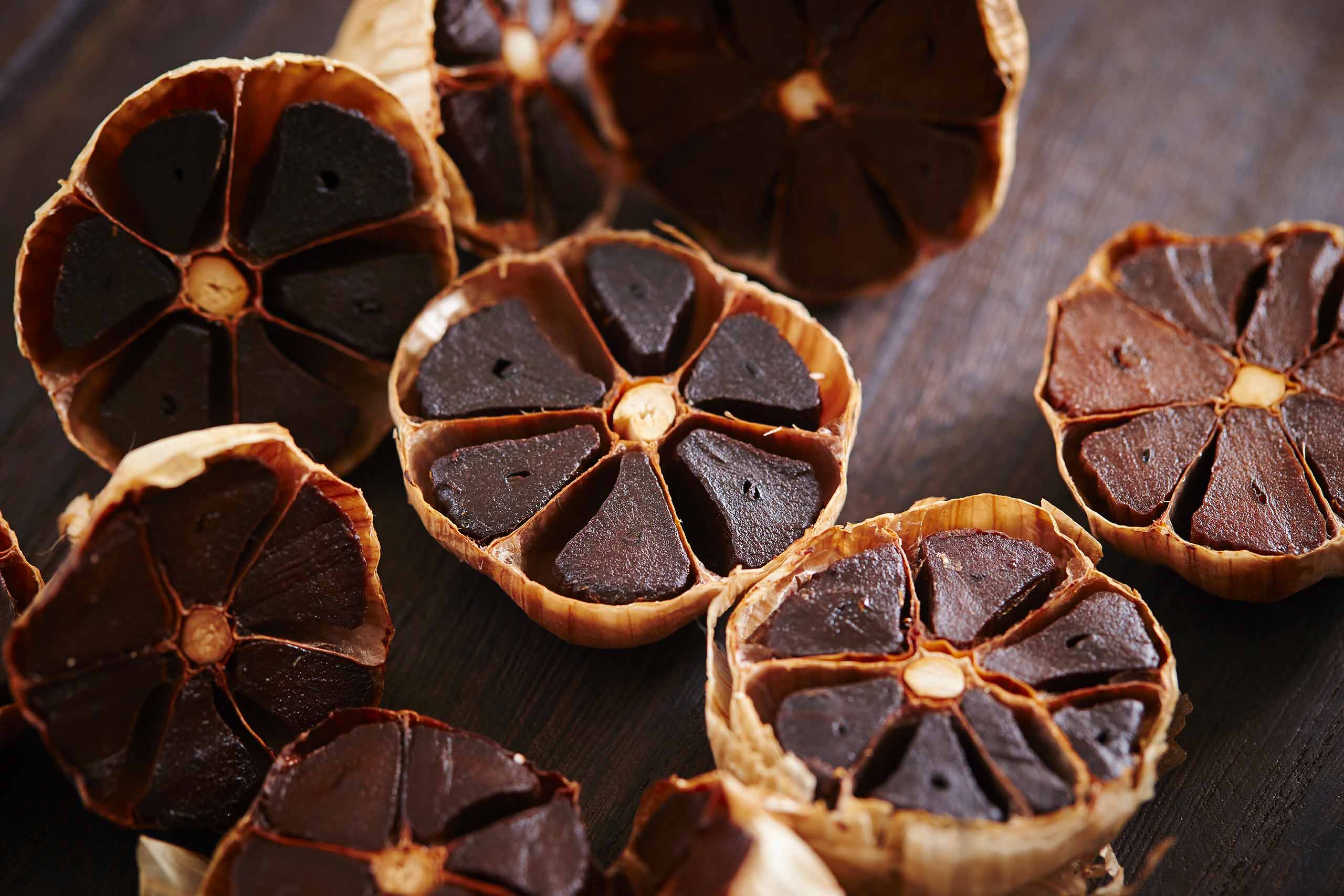 Halved cacao pods opened to reveal dark chocolate segments on a wooden surface.